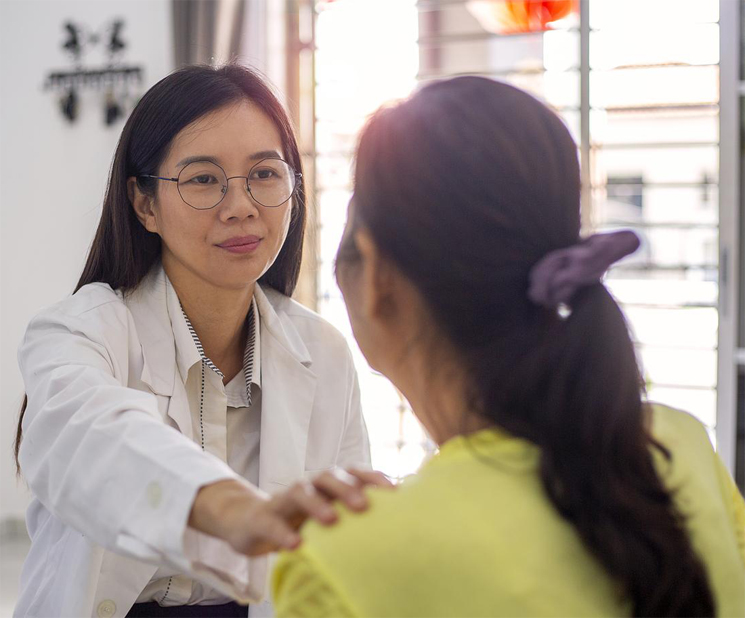Asian female adoctor is comforting female patient at home